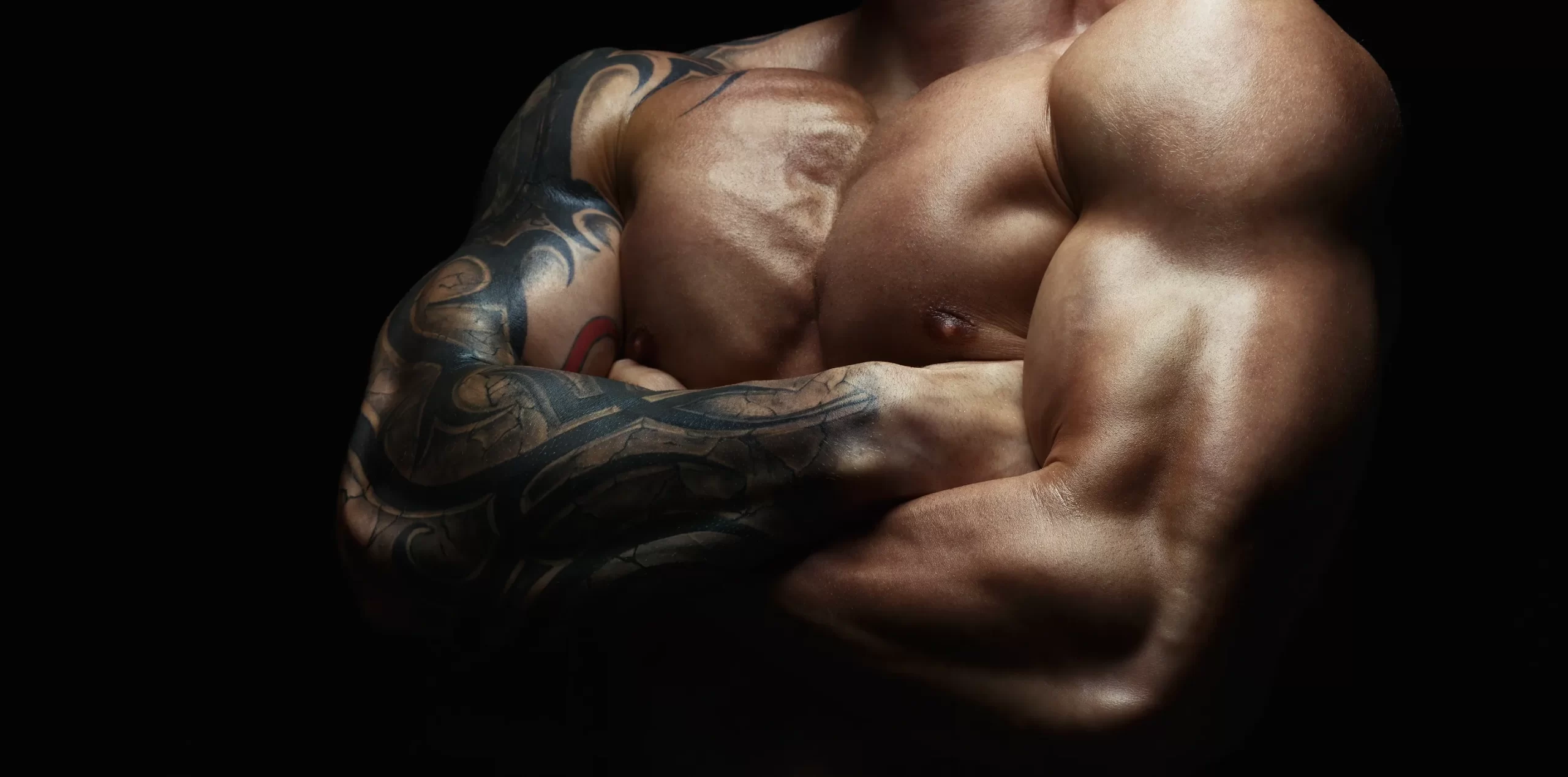 muscular-man-with-tattooed-arms-on-black-backgroun-2026-03-24-02-19-33-utc